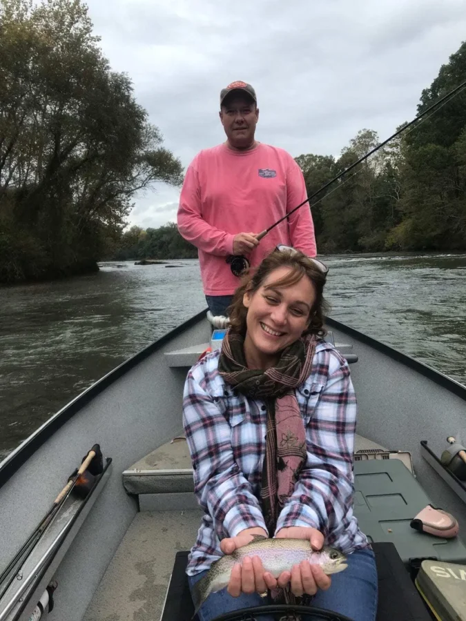 What to Do in Blue Ridge GA: 7 Relaxing Ideas for Your Mountain Getaway 6 What to do in Blue Ridge GA Smiling woman holding a freshly caught rainbow trout while fishing in Blue Ridge, GA with her husband — peaceful outdoor adventure in the North Georgia mountains.