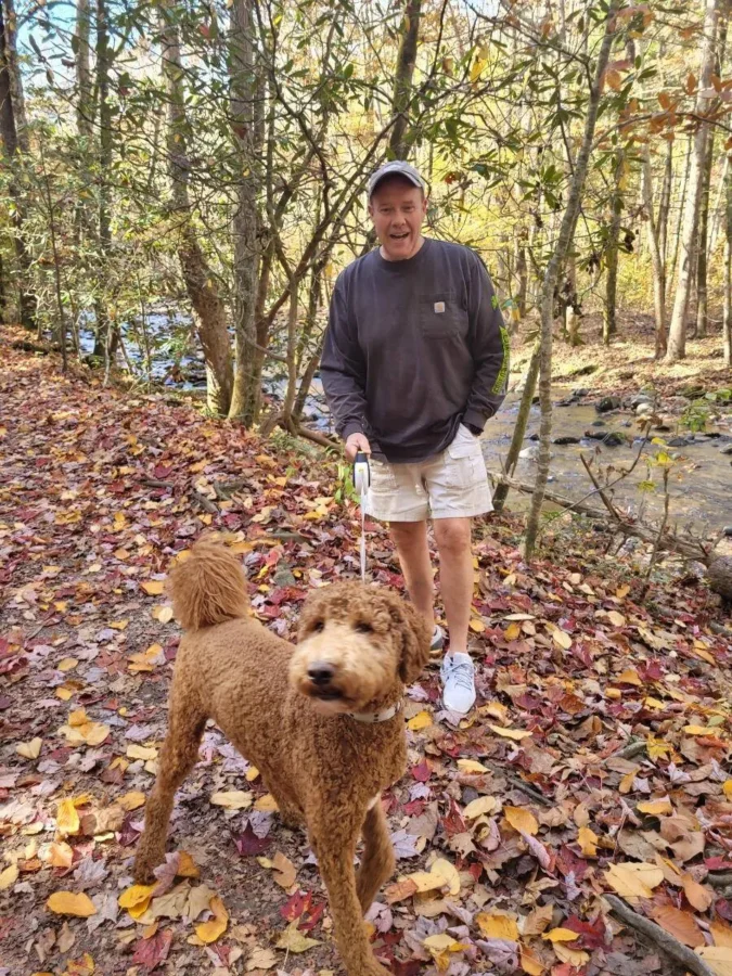 What to Do in Blue Ridge GA: 7 Relaxing Ideas for Your Mountain Getaway 5 Steve walking Mr. Jax along a colorful leaf-covered hiking trail in Blue Ridge, GA near a mountain stream — perfect fall day in the North Georgia mountains.