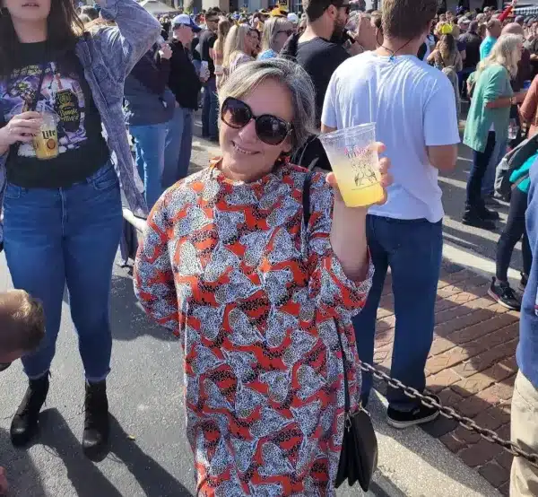 Top things to do in Neptune Beach Florida 3 Woman in a cheetah-print dress holding a drink and smiling at Peteโs Bar Thanksgiving Street Party in Neptune and Atlantic Beaches, Florida, surrounded by a lively crowd. Things to do in Neptune Beach Florida
