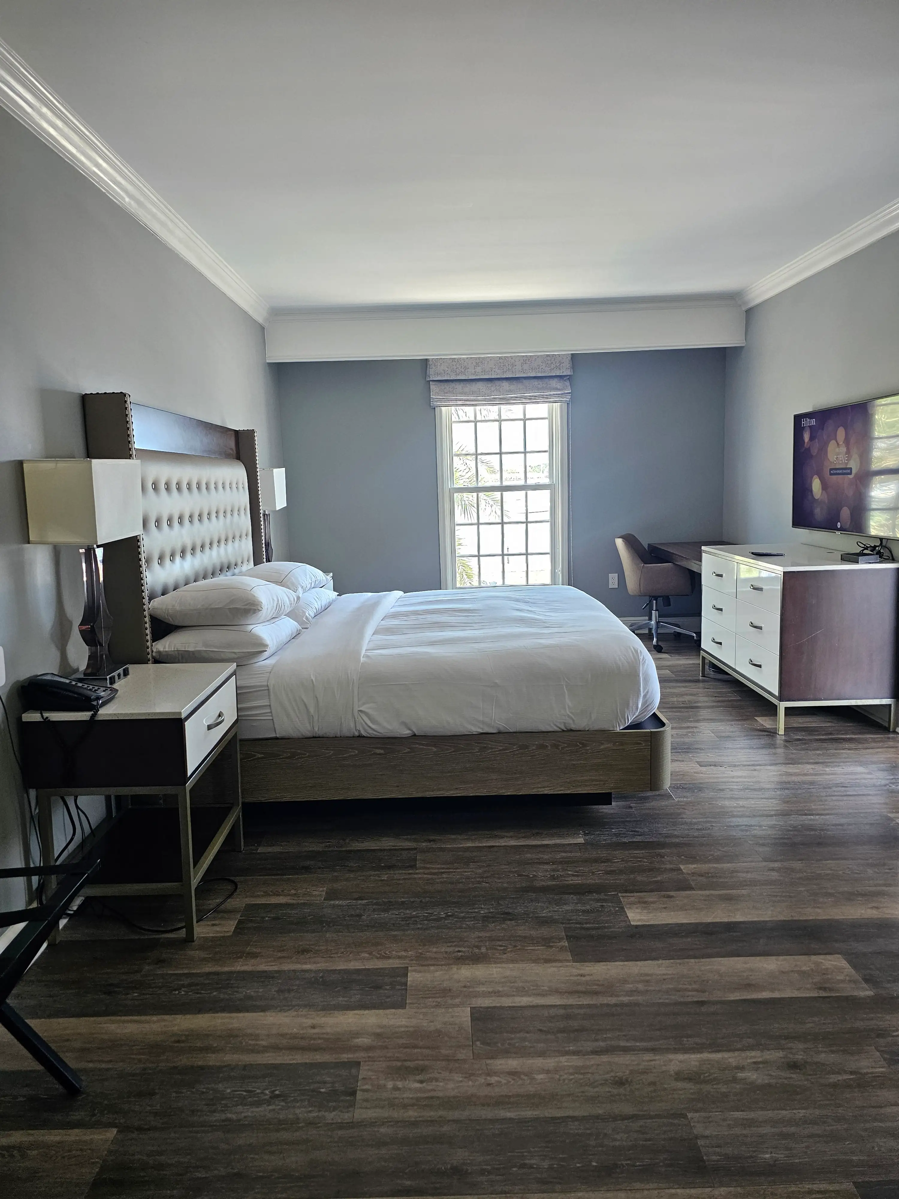 Room 214 at the Hilton St. Augustine Historic Bayfront featuring a spacious king bed, modern decor, hardwood floors, and a large window with natural light—one of the best hotel rooms in downtown St. Augustine Florida.