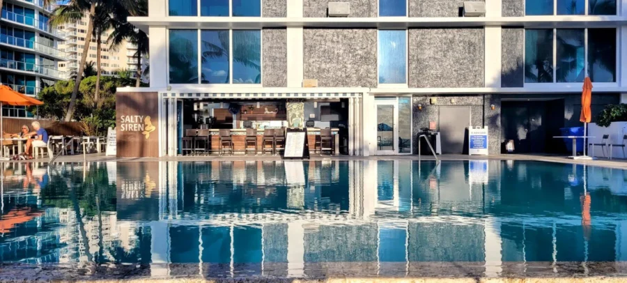 Our Stay at B Ocean Resort Reviewβ A Fort Lauderdale Oceanfront Hotel with Personality 4 The beachfront infinity pool at B Ocean Resort in Fort Lauderdale, Florida, with views of the Salty Siren bar and resort guests enjoying drinks by the water.