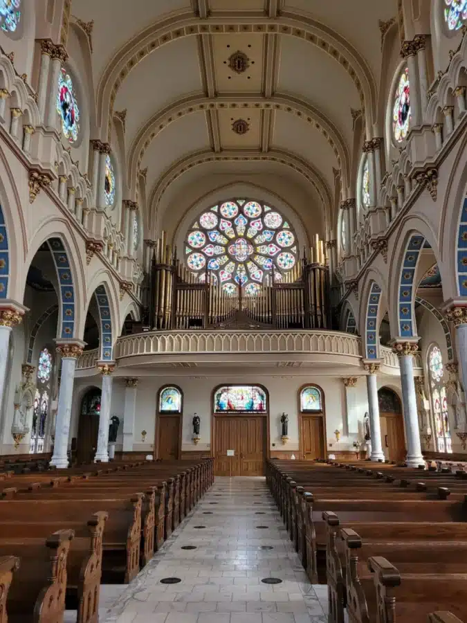 Fun Things to Do in Macon, Georgia 3 Interior view of St. Joseph’s Catholic Church in Macon, Georgia, showcasing stained glass windows, wooden pews, and a large rose window above the pipe organ