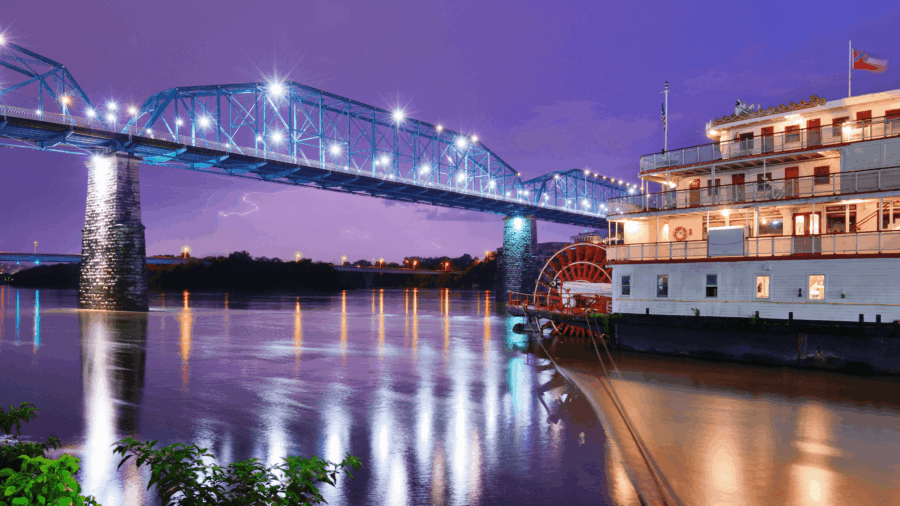 Southern Belle Riverboat lit up at night as it passes under a bridge on the Tennessee River in Chattanooga.