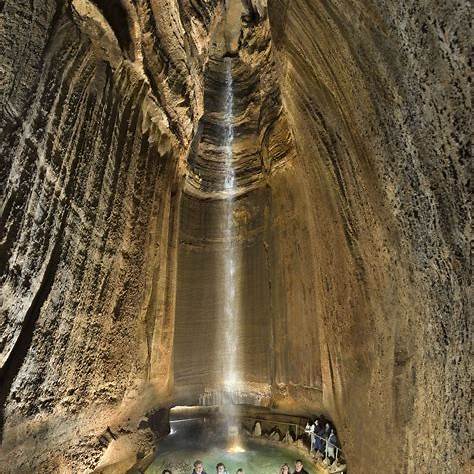 Fun Indoor Things to Do in Chattanooga. Tall underground waterfall glowing under colorful lights inside Ruby Falls cave in Chattanooga.
