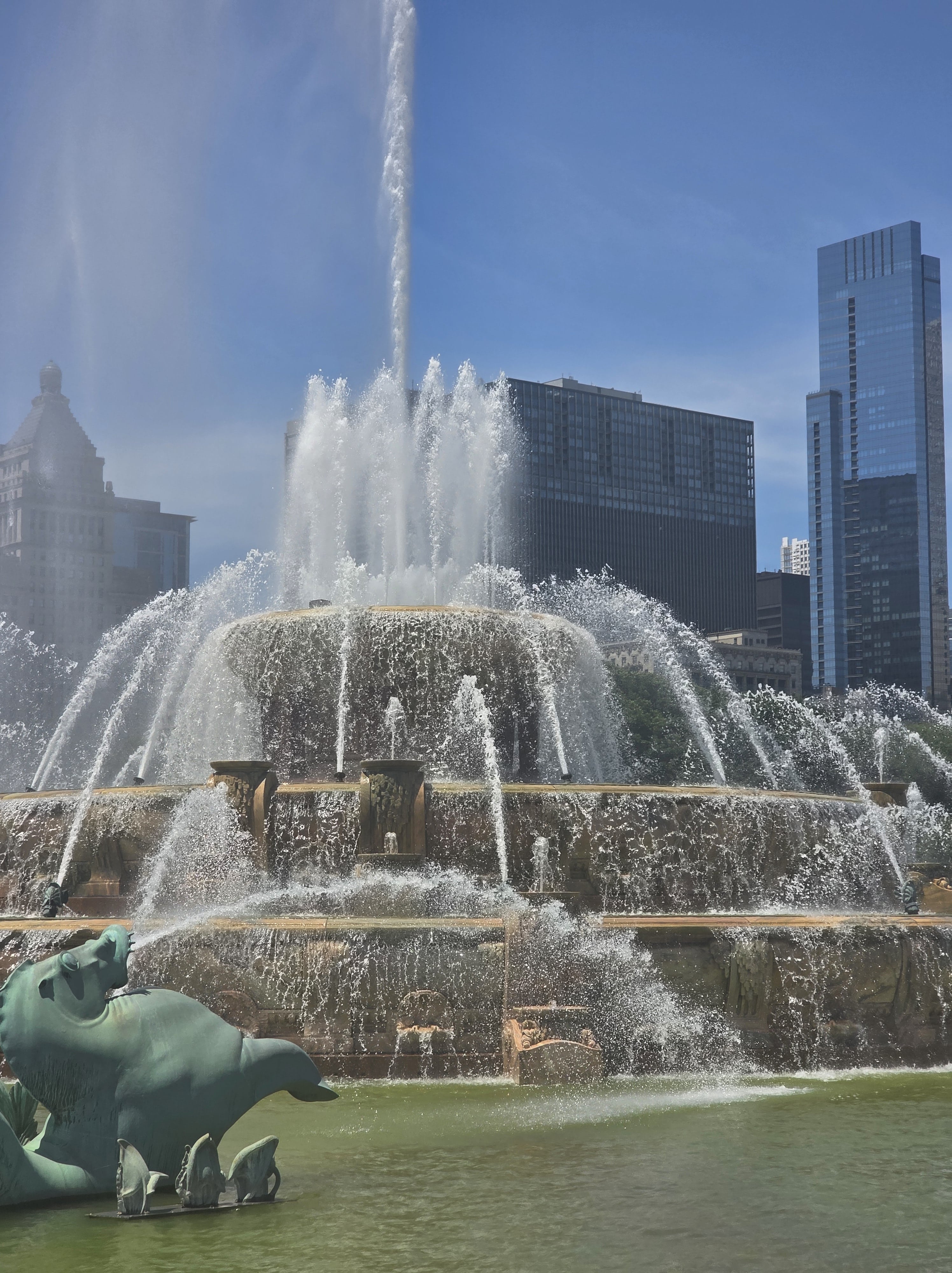 Buckingham Fountain spraying water high into the air on a sunny summer day in Chicago’s Grant Park, with skyscrapers in the background — one of the most iconic things to visit in Chicago.